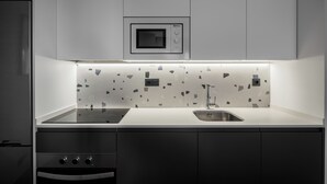 A modern kitchen with a built-in microwave, a sink, and a stovetop.