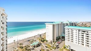 A beachfront hotel with a view of the ocean, multiple floors, and a parking area. - Surfside Resort #1508b (Miramar Beach)