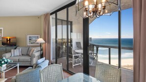 A room with a view of the ocean, a sofa, chairs, and a table. - Surfside Resort #1508 (Miramar Beach)