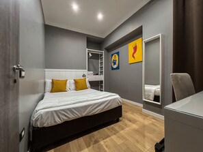 Une chambre à coucher moderne, avec un lit, une armoire, un miroir et des œuvres d’art accrochées au mur.