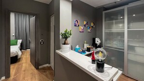 A modern kitchen with a white countertop, a potted plant, and a coffee machine. - Tiè tiè (Naples)