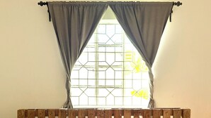 Un lit avec une tête de lit en bois, des oreillers blancs et une couvre-lit à motifs.