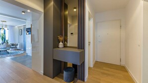 A modern interior with a dark accent wall, a small table with decorative items, and a door to another room. - Apartment Leonarda (Zadar)