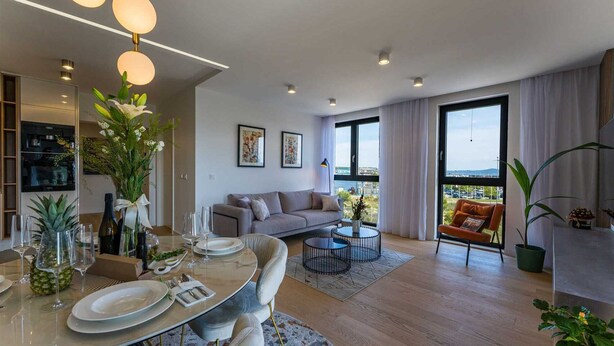 A modern living room with a dining area, a sofa, a coffee table, and a balcony with a view. - Apartment Leonarda (Zadar)