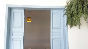 A room with a white door and a hanging plant. - Vilab  (Porto Seguro)