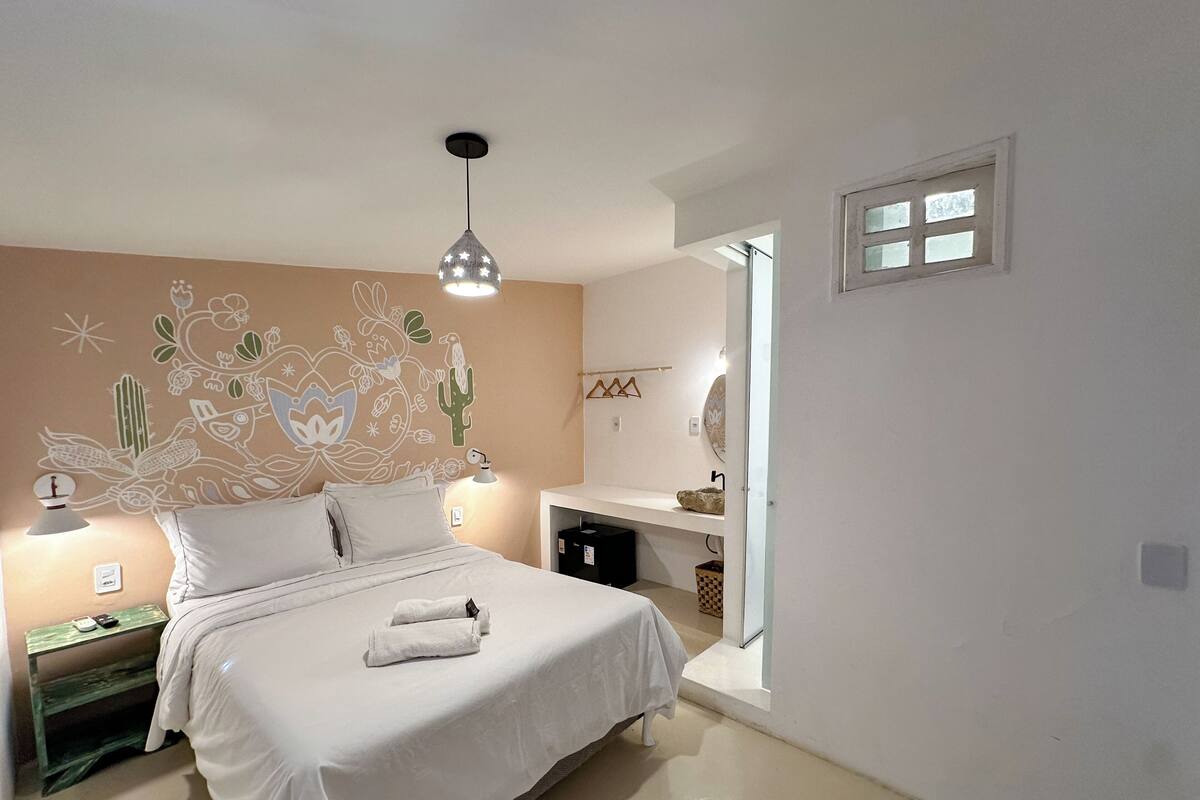 Une chambre à coucher avec un lit, une table de chevet, une lampe et une fresque murale.