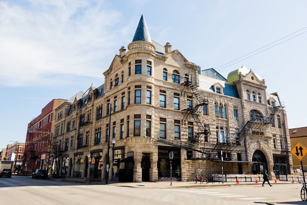 A historic building with a prominent corner turret and a fire escape. - Cozy & Chic 2BR Loft on 18th St in Chicago (Chicago)