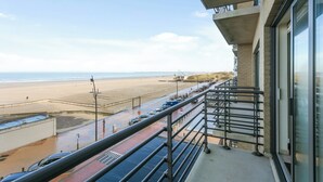 Een balkon met uitzicht op het strand en de zee.