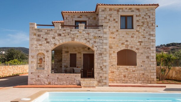 A stone building with a swimming pool, featuring an arched entrance and a patio area. - Ydria Villa A With Pool (Hersonissos)