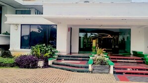 A modern building with a large entrance, steps leading up to the door, and potted plants around the entrance area. - Makati Rio Hotel (Bengkulu)
