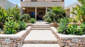 A modern building with a stone pathway leading to a door. - Stunning Villa With Gardens (Sant Josep de sa Talaia)
