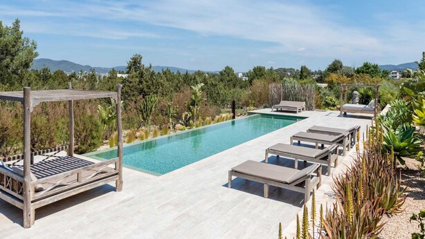 A pool area with a pergola, lounge chairs, and a view of the surrounding landscape. - Stunning Villa With Gardens (Sant Josep de sa Talaia)