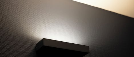 Una pared con textura y un foco empotrado.