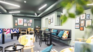 Una moderna area lounge con posti a sedere, tavolini e opere d'arte alle pareti.