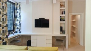 A modern bedroom with a bed, a desk, a TV, and a wardrobe. - St. Peter's  (Roma)