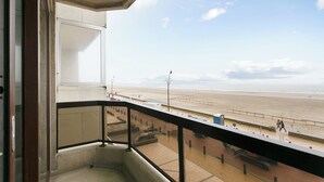 Un balcone con vista su una spiaggia e un cielo sereno.