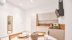 A modern kitchen with white cabinets, a wooden countertop, and a built-in oven.