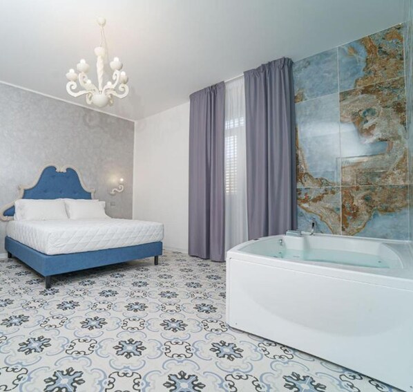 Un dormitorio con cama, lámpara de araña, bañera y un mapa en la pared.