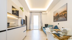 A modern kitchen with a dining area, a TV, and a large window with curtains. - Charming 1-bedroom apt. with AC, WiFi, lift.  in central Roma, close to Colosseo (Roma)
