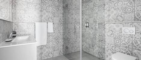A modern bathroom with patterned tiles, a glass-enclosed shower, a white sink, and a toilet.
