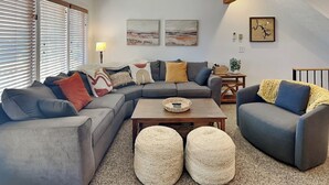 A modern living room with a sectional sofa, two armchairs, a coffee table, and a fireplace. - Happy Time by Taylor Made Deep Creek (McHenry)