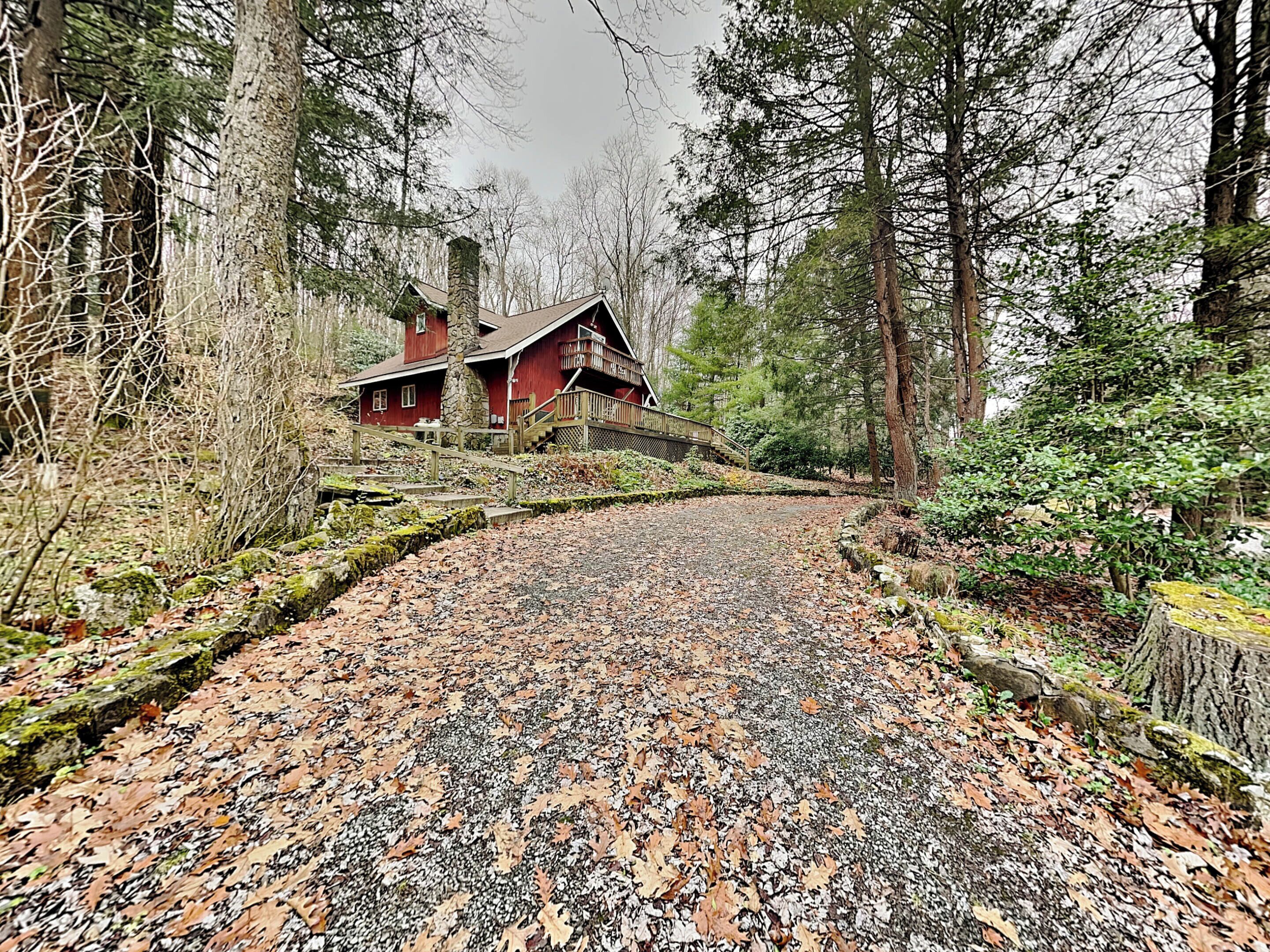 A rustic cabin with a stone chimney, surrounded by a forest.