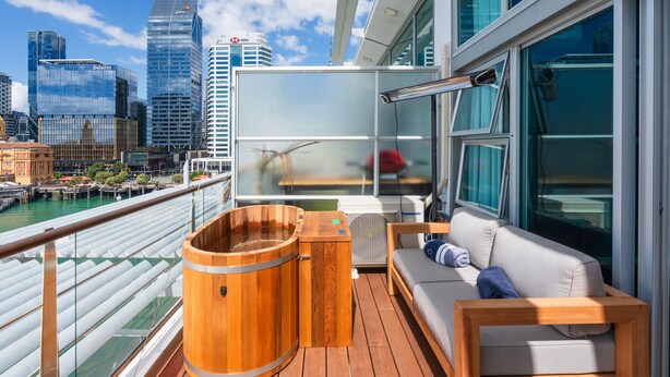 A balcony with a wooden hot tub, a sofa, and a city view. - Princes Wharf - Penthouse - Stunning Views (Auckland)