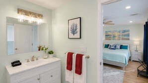 A bathroom with a large mirror, a vanity, and two towels. - Lake George Village -1 Block to Beach, Lake, Town. Newly Remodeled and Spacious. (Lake George)