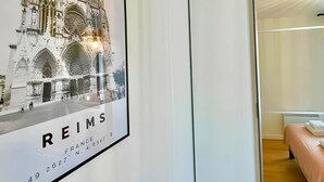 A framed architectural drawing of a cathedral with the text "REIMS" and coordinates "49.2627, N". - L'Éclat Champenois - Gare/Arena (Reims)