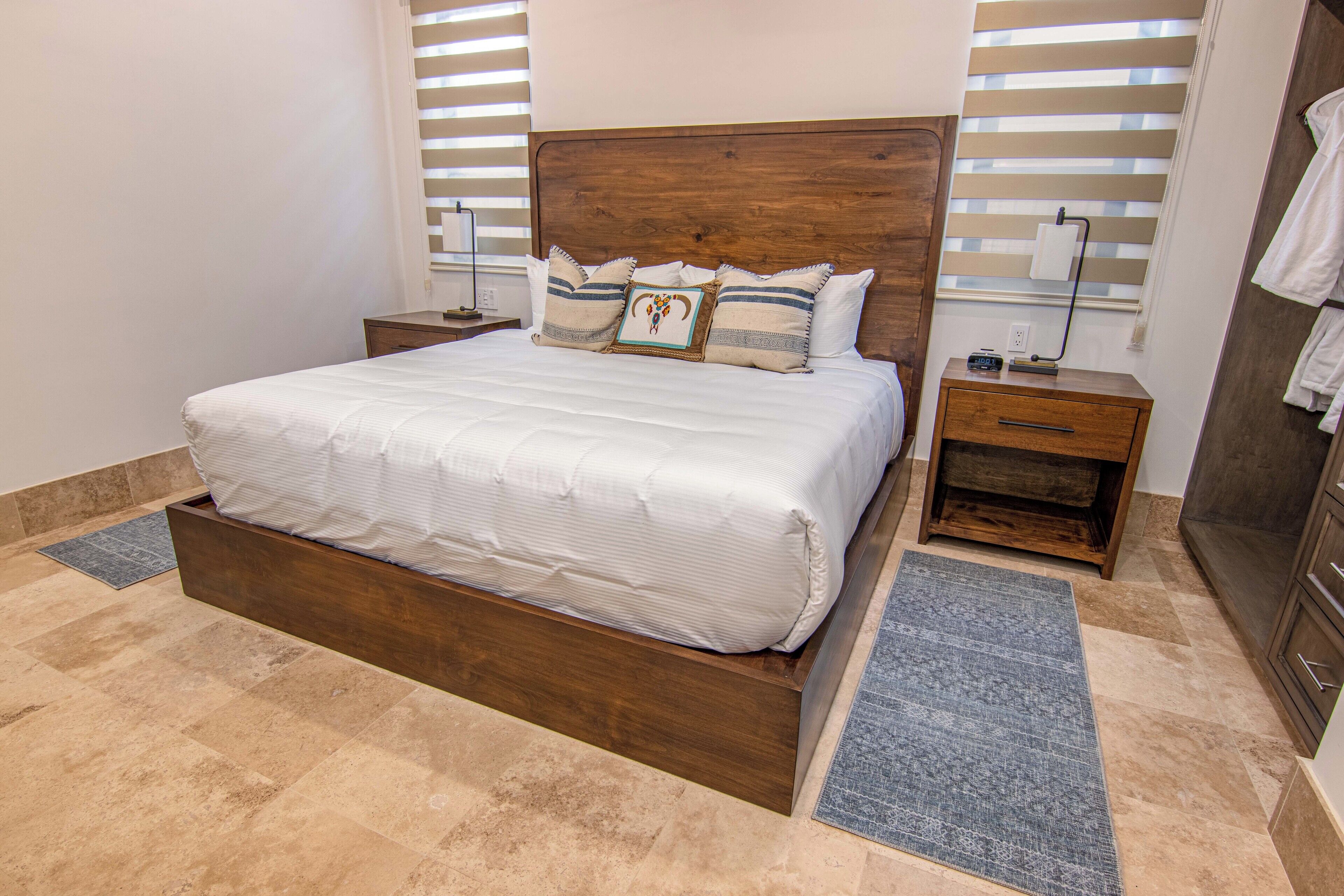 A large bed with a wooden headboard, two bedside tables, and a nightstand.