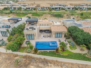 A modern residential complex with multiple houses, a central swimming pool, and landscaped gardens.