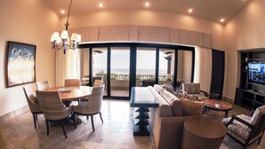 Amplia sala de estar con comedor, sofá y televisión.