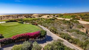 A golf course with a clear view of the ocean and desert landscape.