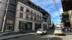 Ein mehrstöckiges Gebäude mit moderner Fassade, großen Fenstern und Balkonen.