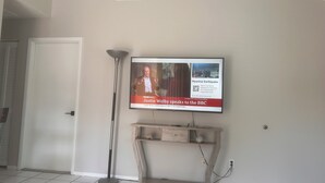 Un televisor fijado en una pared mostrando un noticiero.