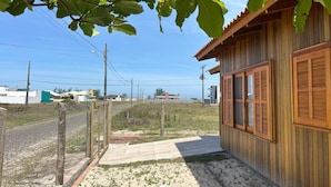 A wooden building with a tiled patio and a fenced area.