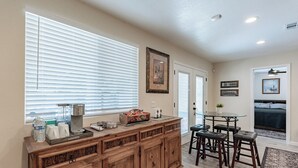 A kitchen with a wooden island, bar stools, and a dining table. - Gilbert AZ 4BR Vacation Home Remodeled Garage (Gilbert)