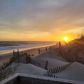 A beach with a wooden fence and sand dunes. - Island Time is an enchanting oceanfront cottage perfect for couples (Hatteras)
