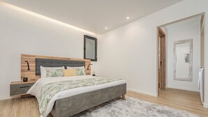 A modern bedroom with a grey bed, wooden headboard, and a fluffy rug. - Alpine escape villa Vienna apt Gaula Madeira  (Gaula)