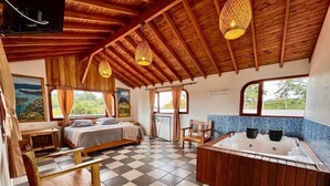 A cozy room with a bed, a wooden bench, a bathtub, and a checkered floor. - Alto del sion  peñol guatape  (El Peñol)