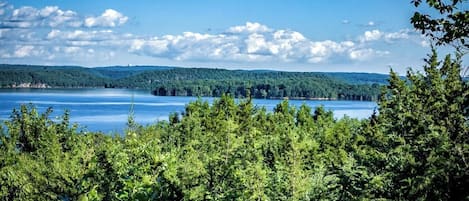 Un lac entouré d’une forêt dense et de collines.