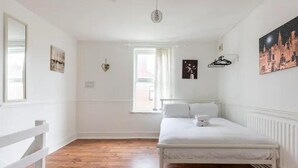 A bedroom with a bed, a window, and a radiator. - Cheerful Maisonette in the Heart of Orrell Park (Liverpool)