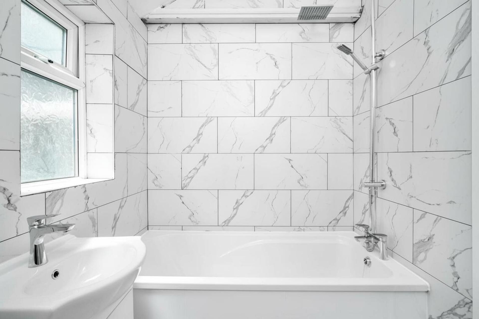 A bathroom with a bathtub, a sink, and a shower.