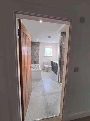 Un baño moderno con bañera, inodoro y lavamanos.