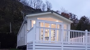 Un edificio bianco a un piano con un balcone e un'area recintata.