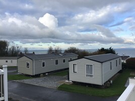 Una hilera de casas móviles con vista al mar y un cielo nublado.