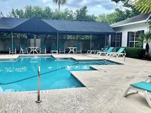 A swimming pool with lounge chairs and a covered area. - La Vie Insulaire -optional BIKES–Walk 2 Redfern Village, shops, and restaurants! (St. Simons Island)
