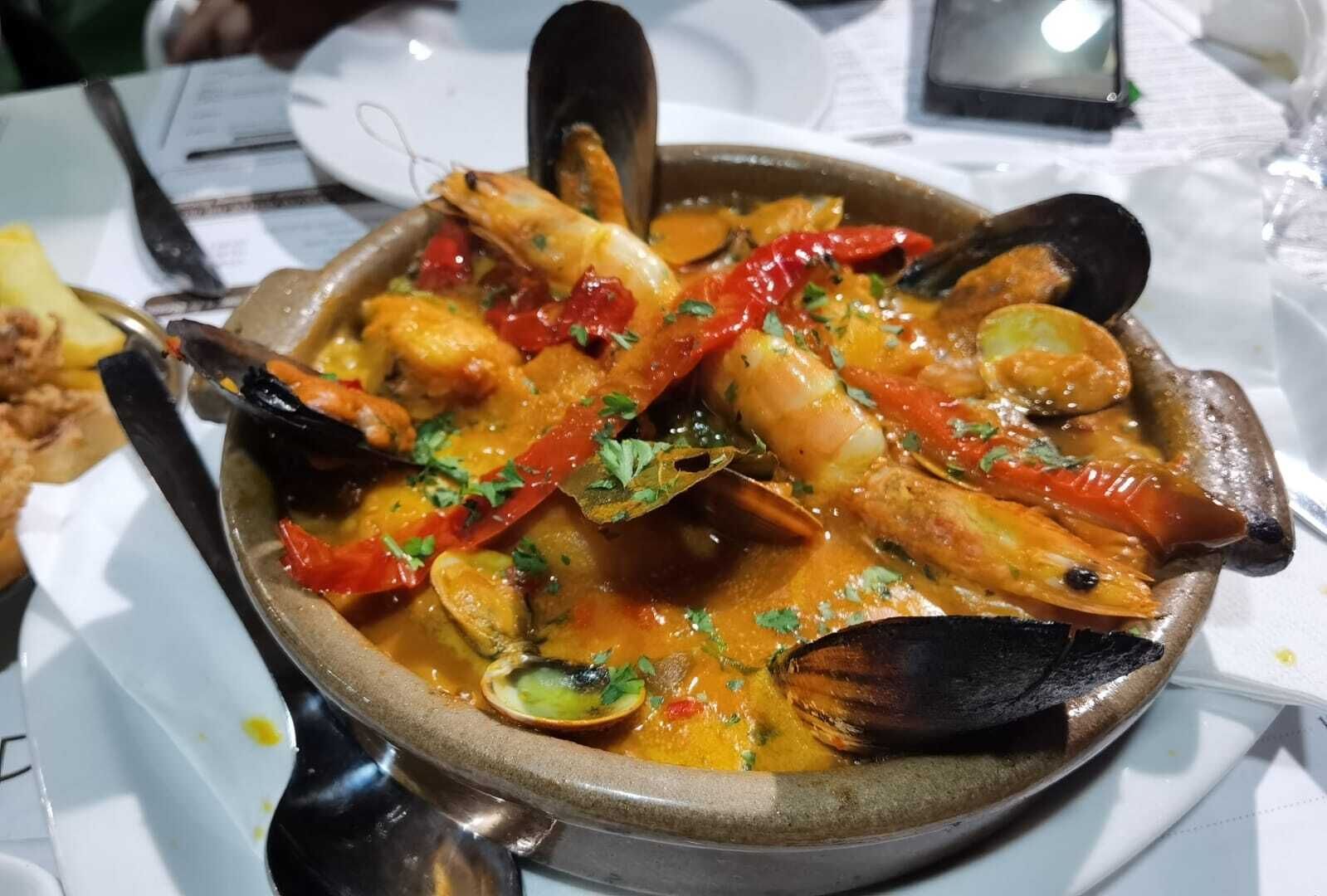 Un plato de mariscos con mejillones y camarones en una olla.