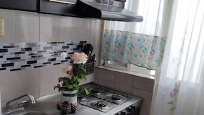 A kitchen with dark cabinets, a stainless steel sink, a gas stove, and a tiled backsplash. - Charming Mexican Retreat in San José de los Olvera (Corregidora)