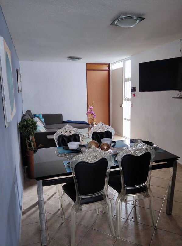 A dining area with a table set for four, surrounded by chairs with ornate metalwork. - Charming Mexican Retreat in San José de los Olvera (Corregidora)